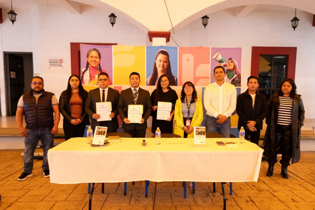 Panelistas y autoridades posan con ejemplares del libro “Tus obligaciones en… materia de trabajo y seguridad social”, al finalizar el evento en Xonacatlán.