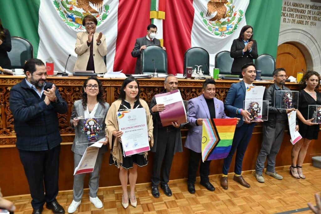 Foto grupal de las personas premiadas con la Presea Israfil Filós Real, cada una con su reconocimiento en mano, junto a diputadas, diputados y diputade, celebrando la diversidad y la defensa de los derechos humanos.